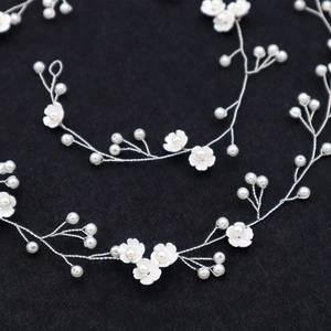 Silver bridal hair vine featuring white flowers and pearls for wedding hairstyles