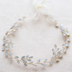 Macro detail of leaf-shaped light blue stones on a gold woven bridal headband