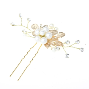 Détail d'épingle à cheveux dorée avec perles blanches et cristaux pour mariée