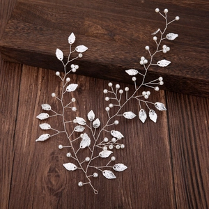 Detail von Braut-Haarschmuck mit silbernen Blättern und Perlen auf einem Holzgrund