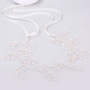 Dettaglio della vite per capelli da sposa dorata con perle e nastri di raso
