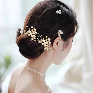 Vue détaillée du peigne à cheveux doré avec perles et collier de perles pour la mariée