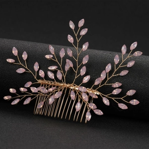 Detailed macro of golden wire hair comb with pink crystals in a vine branch pattern