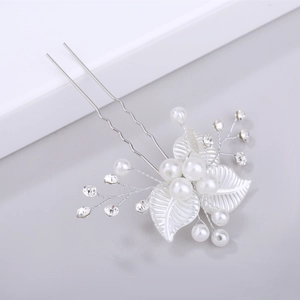 Détail d'épingle à cheveux mariée avec perles blanches, strass et feuilles argentées