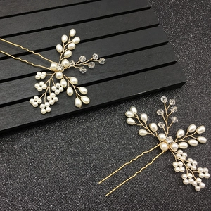 Détail de pinces à cheveux de mariée avec perles blanches et motif floral doré