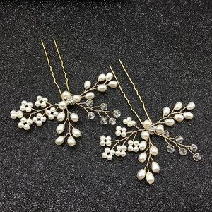 Détail d'épingles à cheveux dorées avec perles blanches et perles en cristal clair