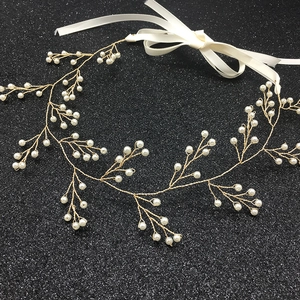 Vista dettagliata della fascia da sposa fatta a mano in filo dorato con perle bianche