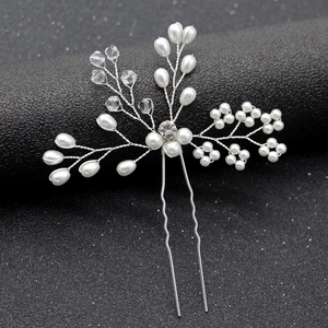 Détail d'une épingle à cheveux de mariée en perles faites main avec fil argenté sur noir