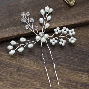 Détail d'épingle à cheveux mariée argentée avec perles blanches et cristaux sur bois