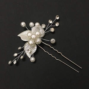 Détail de l'épingle à cheveux de mariée avec feuilles argentées, perles blanches et strass