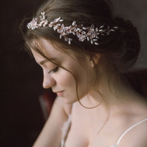 Detail eines Braut-Haarranke in Roségold mit rosa Kristallblüten und weißen Perlen am Modell