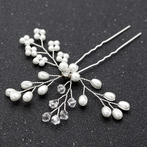 Détail d'une épingle à cheveux de mariée avec perles et cristaux sur un fond sombre élégant