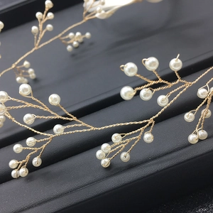 Dettaglio ravvicinato della fascia per sposa in filo dorato con eleganti perle bianche