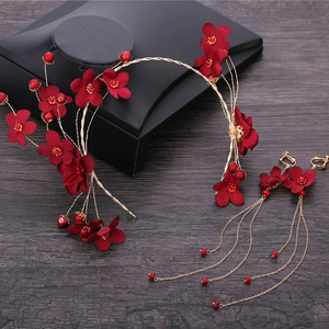 Detail von rotem Brautschmuck mit Blumen und langen Quasten-Ohrringen in Gold
