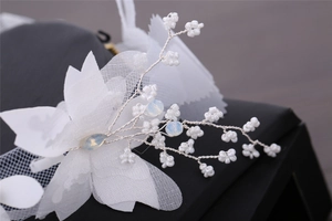 Détail d'accessoire floral fait main blanc avec perles et pétales en organza