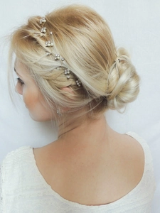 Detailed view of bridal pearl and rhinestone hair vine on bride's elegant hairstyle