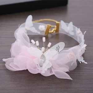 Détail d'un ras de cou en dentelle papillon rose avec perles et fermoir doré