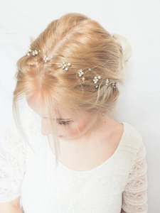 Detail of bridal hair vine with white pearls and crystals on gold wire for weddings