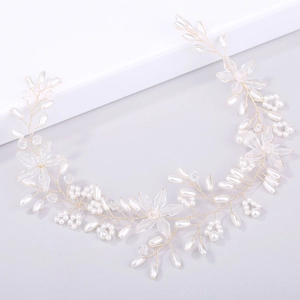 Detail von handgefertigtem Braut-Haarschmuck mit Perlen, Kristallen und Goldblüten