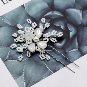 Close-up of handmade bridal flower hair pin with white beads, pearls and crystals