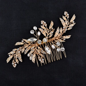 Elegant gold leaf bridal hair comb with crystals and pearls on black leather background