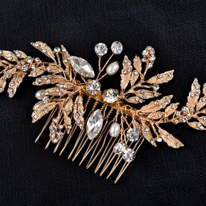 Detail of bridal hair comb with golden leaves, sparkling rhinestones, and white pearls