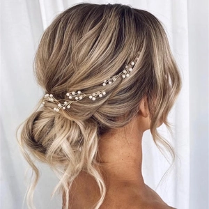 Elegante tralcio per capelli da sposa dorato con perle bianche su acconciatura intrecciata