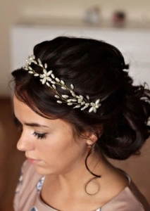 Detail of bridal hairpiece with white pearls and gold wire woven into flower patterns