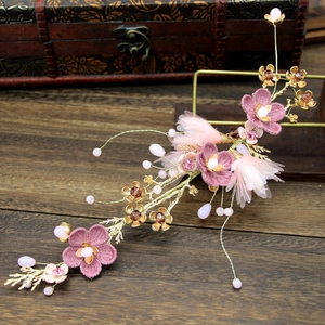 Detail of pink fabric flowers and golden metal branch hairpiece for bridal styling