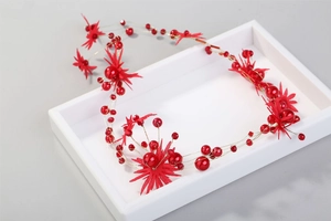 Detail of red pearl bridal hair vine with gold wire and star floral accents