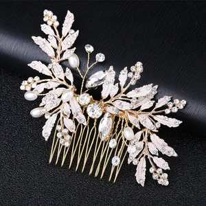 Elegant gold leaf hair comb with white pearls and rhinestones on a black background