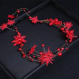 Detail of red handmade floral bridal headband with golden wire and pearl embellishments