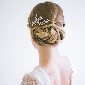 Détail du peigne de mariée avec feuilles blanches et fils dorés pour mariage