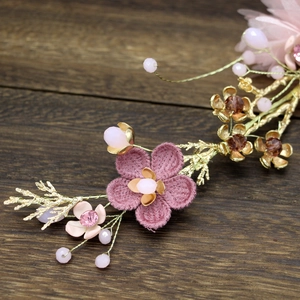 Detailed close-up of bridal headpiece with pink fabric petals and golden metallic leaves