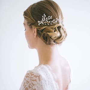 Détail du peigne à cheveux mariée avec feuilles d'opale et cristaux sur cheveux blonds