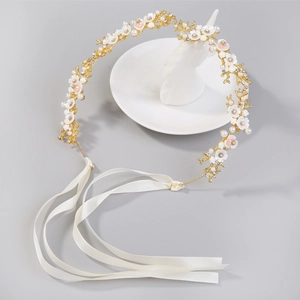 Détail d'un bandeau de mariée avec fleurs blanches, perles et fils dorés élégants