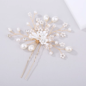 Détail d'épingle à cheveux de mariée avec perles, cristaux et motifs de fleurs dorées