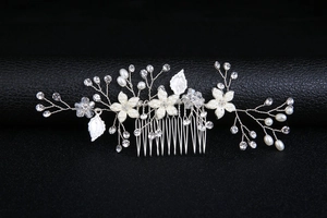 Détail d'un peigne à cheveux de mariée fait main avec feuilles argentées et perles