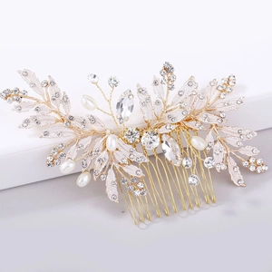 Detailed close-up of bridal hair comb featuring golden leaves, white pearls and rhinestones