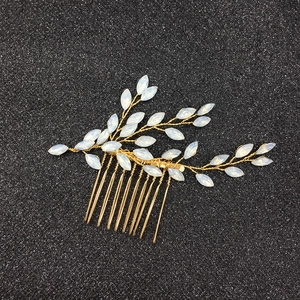 Détail macro du peigne de mariée avec branches dorées et feuilles d'opale blanches