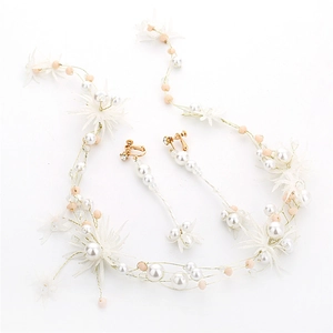 Detail of handmade bridal hair vine and matching pearl drop earrings with mesh flowers