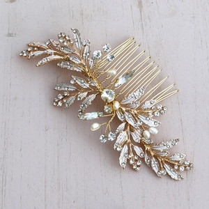 Detail of bridal hair comb with golden leaves, sparkling rhinestones and white pearls