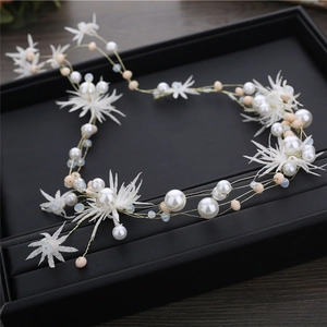 Elegant bridal hair vine with white fabric flowers and pearls on golden wire