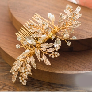 Macro shot of gold leaf bridal hair comb with sparkling rhinestones and pearls