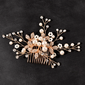 Détail d'un peigne à cheveux de mariée fait main avec fil doré, perles blanches et strass