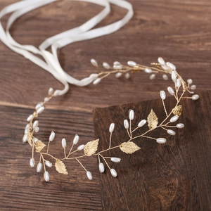 Détail d'un bandeau de mariée baroque fait main avec feuilles dorées et perles blanches