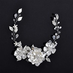 Détail d'un bandeau de mariée avec perles blanches, feuilles argentées et gouttes de cristal