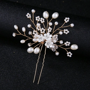 Détail d'épingle à cheveux mariée avec perles blanches, fleurs en résine et cristaux