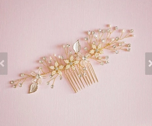 Détail d'un peigne de mariée avec perles, cristaux et feuilles dorées sur fond rose