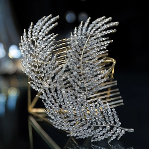 Elegant gold bridal hair comb with rhinestone leaf design on black reflective surface